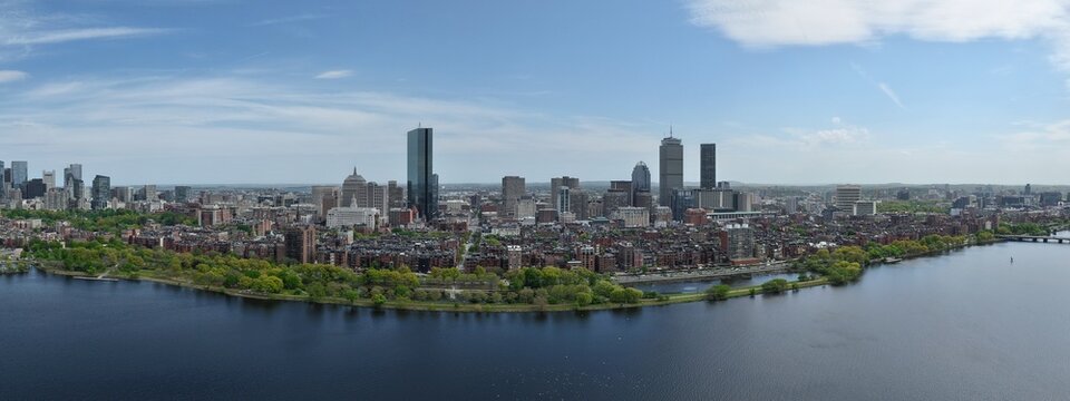 Panoramic aerial drone view of Boston Back Bay skyline, Prudential Tower, and Charles River Esplanade on a clear summer day, featuring historic brownstones and city skyscrapers, USA.