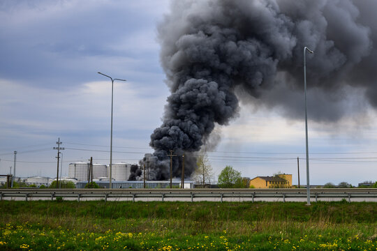 Massive black smoke from industrial oil depot fire, air pollution, environmental disaster and energy crisis concept