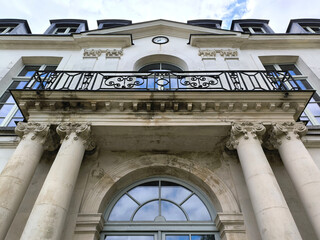 Low Angle View of Ornate Classical French Building Facade with Corinthian Columns, Wrought Iron Balcony and Clock © Maroun Rached