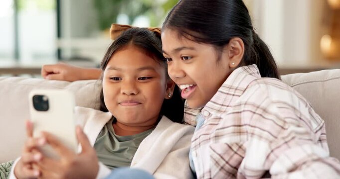Happy, girls or siblings with phone on sofa for social media, connection or texting in home. Sisters, kids or children with smile on mobile smartphone for online chatting, message or network in house