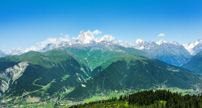 Mestia Georgia Caucasus mountain panorama with Ushba peaks, green valleys, snow glaciers, alpine travel destination landscape.