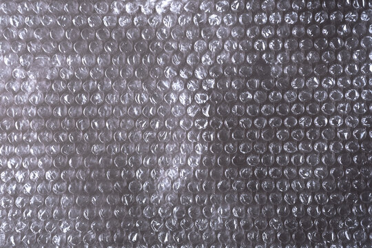 Primer plano de una l&aacute;mina de pl&aacute;stico transparente con textura de burbujas sobre fondo blanco. Textura de pl&aacute;stico con burbujas para dise&ntilde;o de protecci&oacute;n de env&iacute;os de comercio electr&oacute;nico, cat&aacute;logos 