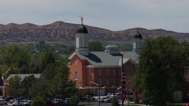 Zoom aerial of church in Vernal Utah at sunset in Uinta Mountains