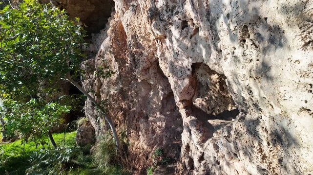 Ancient porous tufa limestone cliff wall in Kaleici old town Antalya with rough weathered natural texture.