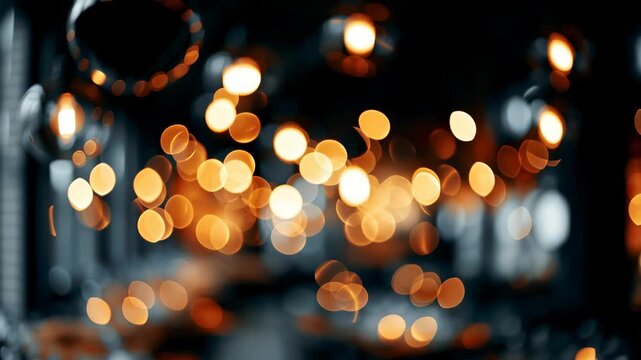 Warm bokeh light bulbs create an abstract, defocused background with a golden orange glow, conveying a festive or cozy atmosphere. This cinematic b roll footage can be used as an overlay, transition, 