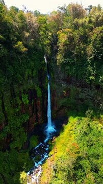 Breathtaking high angle shot of iconic Kapas Biru waterfall &ndash; Epic wild nature landscape with powerful water stream hidden in lush green jungle canopy, Java Indonesia commercial stock footage