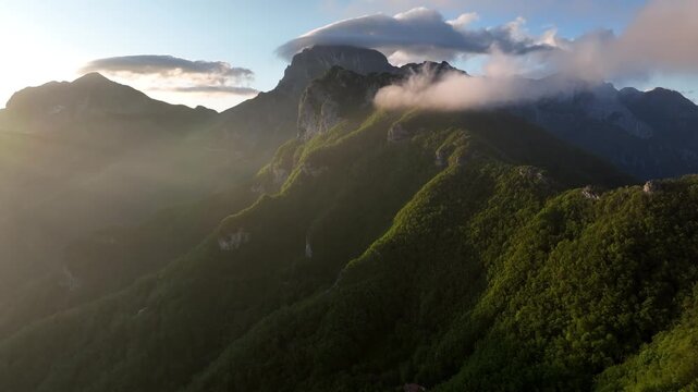 Aerial view of Foce del Pallone mountain pass with misty ridges and golden sunset light in the Apuan Alps, Stazzema, Toscana, Italy.