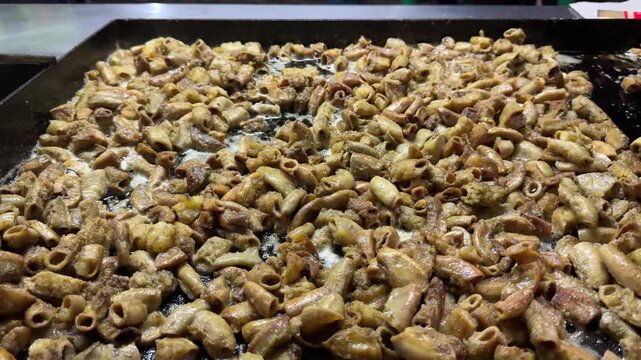Korean street food chitterlings grilling on a hot plate