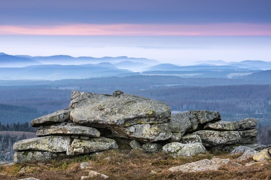 Sunrise on the Brocken, view over hills and forests with valley fog, in front the witch altar, Harz National Park, Saxony-Anhalt, Germany