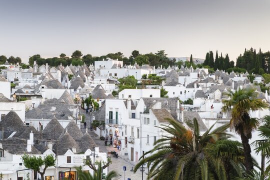 View of the Rione Monti district at dusk, trulli, traditional round houses, trullo settlement, Alberobello, Valle d'Itria, Trulli Valley, Apulia, Italy
