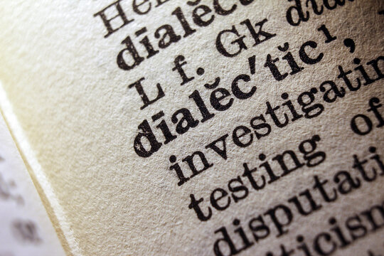 Word dialectic on dictionary page, macro close up