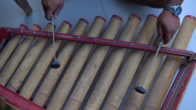 Traditional Balinese musician playing bamboo rindik gamelan
