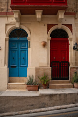Fototapeta premium Epic Malta traditional blue wooden door ancient architecture vertical panorama. Cinematic view of historic limestone house facade, classic stone portal frame, brass door knockers and vintage iron la