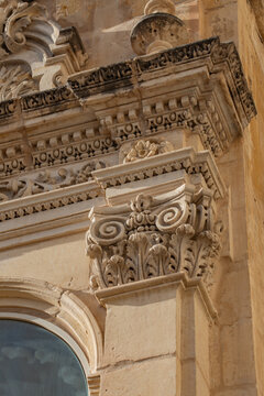 Malta baroque architecture detail ancient stone carvings building facade vertical view.
