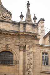 Fototapeta premium Vertical view of ancient baroque cathedral facade. Detailed stone carvings, columns and holy statues. Abstract historic european architecture background. High resolution 33MP. 