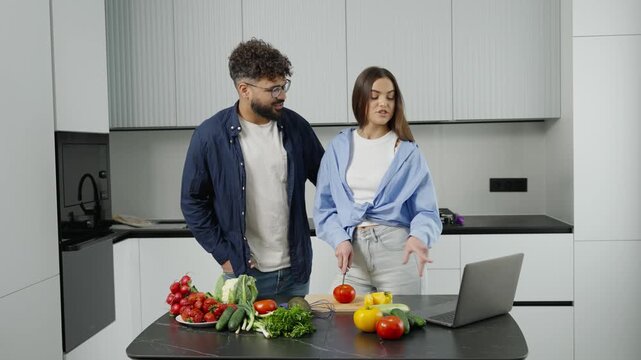 Couple cooking healthy food together following online recipe