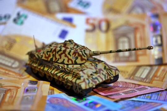 Toy tank on euro banknotes symbolizing military spending and defense budget in Europe