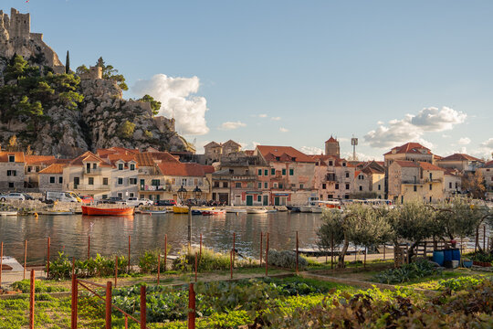Epic Omis town river view panorama. 
Cinematic ground view of old houses, 
boats in water and historic Mirabella 
fortress on rocky cliff in Croatia.

