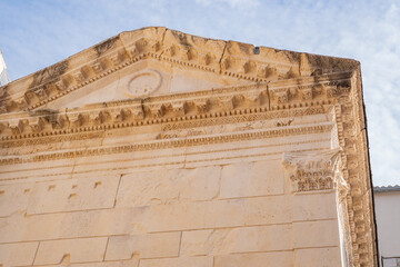 Epic Split Jupiter temple pediment detail.  Cinematic low angle view of ancient Roman carved  limestone cornice and historic roof frieze  inside Diocletian Palace in Croatia.  © Yar
