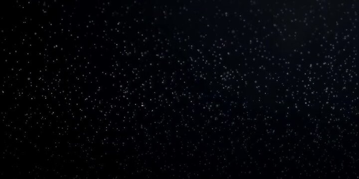 Cinematic floating dust particles shimmering on a black background