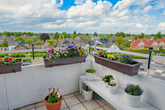 Colorful rooftop balcony garden with suburban view under dramatic cloudy sky