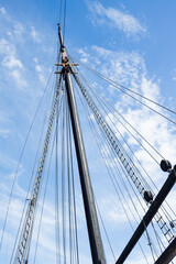 Obraz premium Sailboat Mast and ropes with cloudy blue sky background