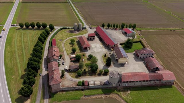 Agricultural Estate from Above: A sprawling agricultural estate unfolds from an aerial perspective, showcasing rows of cultivated fields, farm buildings, and a tranquil pond.