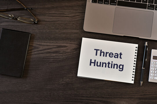 Corporate and management concept of Threat Hunting represented on notebook with laptop, calculator, glasses. Professional business leadership and operations.