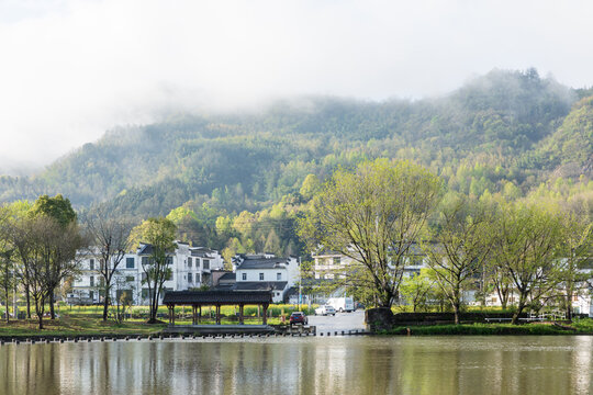 The mountains beside the river are shrouded in mist.