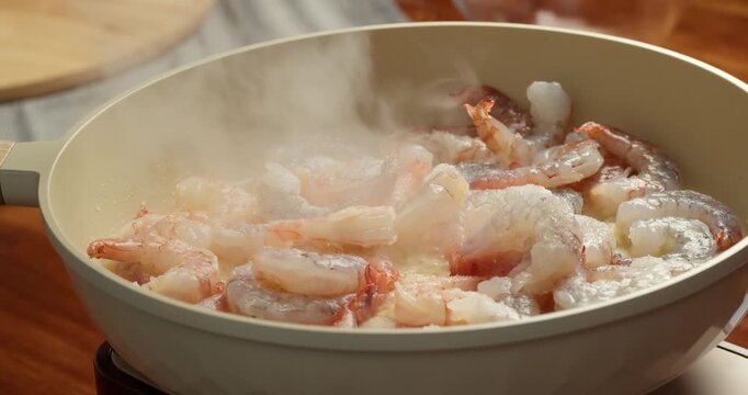 Shrimp turning orange while cooking in pan close up doneness process