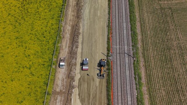 Railway Construction from Above: An aerial view captures the ongoing construction of a railway line, with heavy machinery working on the ballast.