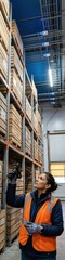 Fototapeta premium Industrial storage racks and a woman holding a digital scanner in a cold chain warehouse for agricultural IoT, food logistics and supply chain management with copy space