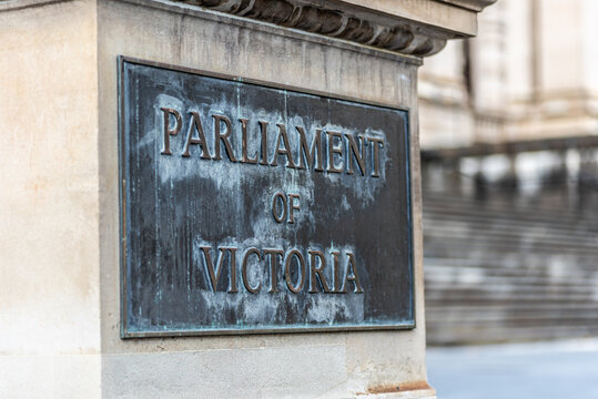 A brass sign on a wall reading "Parliament of Victoria" outside Parliament House on Spring Street in Melbourne, Australia.