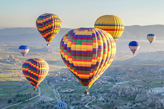 Aerial view of colorful hot air balloons floating over the unique rock formations and valleys of Cappadocia Kayseri, Kayseri, Turkiye.