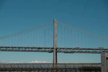 Obraz premium The iconic San Francisco-Oakland Bay Bridge (I-80) , a 8.4-mile, double-decked, state-owned toll bridge connecting San Francisco and Oakland via Yerba Buena Island with blue skies