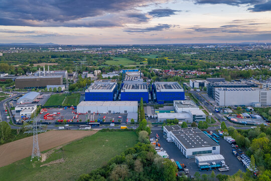 Aerial view of the Digital Realty Frankfurt FRA30 data center complex with modern industrial buildings and green fields under an evening sky in Frankfurt am Main, Hessen, Germany.