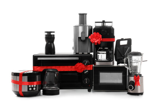 Different household appliances with gift bows isolated on white background