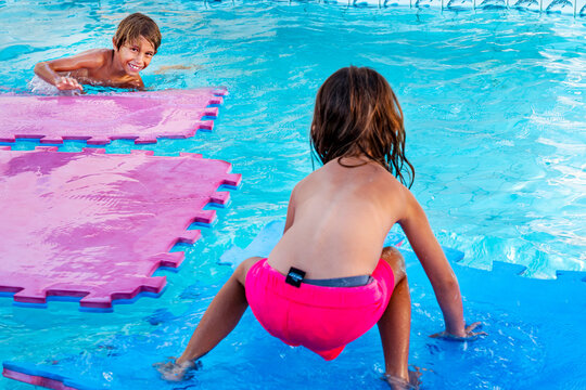 A brother and sister playing happily in the pool. Bras&iacute;lia, Brazil, 2025