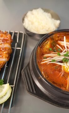 Korean kimchi jjigae stew with sesame chicken cutlet