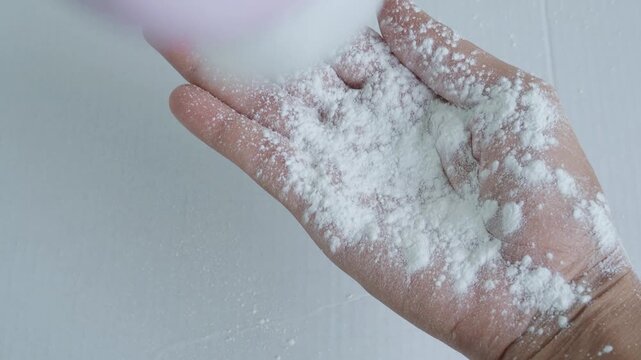 Talcum to hand on white background,baby powder on woman hand close up, dry powder care higiene for people, cosmetic for good health concept.