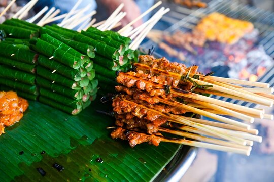 Traditional Vietnamese Bo La Lot and Thit Nuong pork skewers are displayed on a fresh banana leaf at a street food market stall in Hoi An Vietnam
