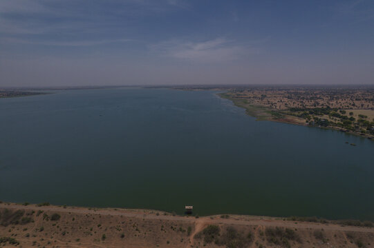 Aerial view of Minjibir dam and the surrounding arid landscape under a clear blue sky in Kano, Kano State, Nigeria.