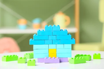 Fotobehang Lego Toy house made of colorful plastic building blocks on white table in children's room  © Pixel-Shot