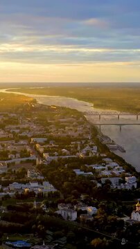 Vertical video. Yaroslavl, Russia. Monument to the 1000th Anniversary, 20-meter granite stele crowned with a gilded double-headed eagle, Drone footage at sunset where the Kotorosl meets the Volga. Dr