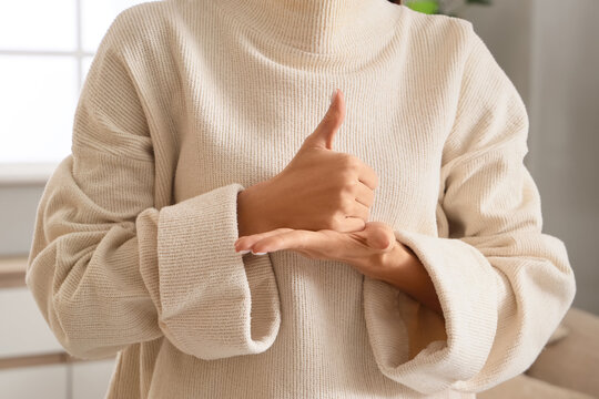 Young woman using sign language at home, closeup