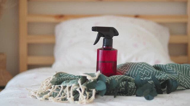 Cleaning spray bottle on bed with cloth and decor