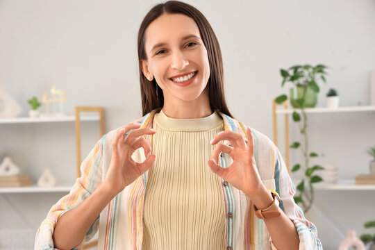 Young happy woman using sign language at home