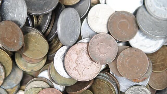 Coins from different countries in a metal bowl