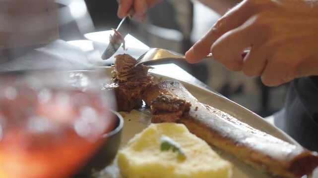 Gourmet grilled meat served with mashed potatoes and sauce in restaurant setting, fancy dinner reveal cutting and preparing perfect bite