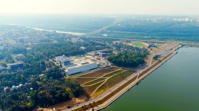 Kaluga, Russia. Tsiolkovsky State Museum of Cosmonautics, its angular metallic facade and parabolic planetarium dome set beside the Yachenka River, Drone footage under bright daylight. Drone footage